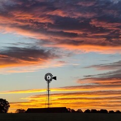 A windmill surrounded by sunset clouds