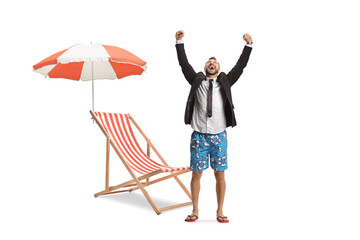 Excited businessman on a holiday next to a beach chair and umbrella