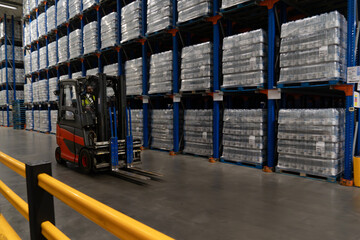 Forklift operator in the forklift truck in the warehouse aisles