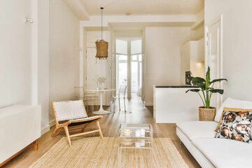 A cozy and inviting modern living room featuring a clean white couch, transparent chairs, and nature-inspired decor, located at Schippersstraat 5