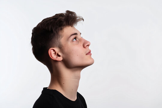 Silhouette of handsome man in black t-shirt on white background, isolated portrait of young guy with short hair and sidecut looking up, profile view, isolated


