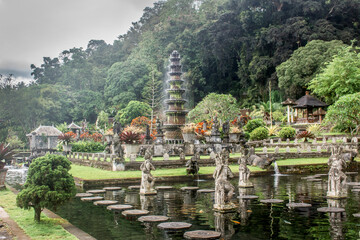 Tirtagangga water palace in Bali. Water fountains, sush green vegetation. Zen and relaxing.