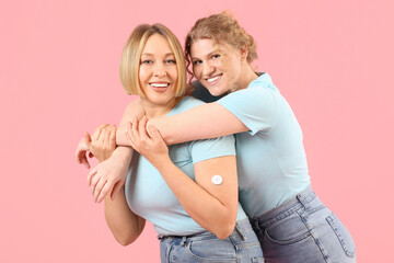 Beautiful happy women in stylish jeans hugging on pink background