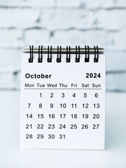October 2024 white monthly desk calendar on a table