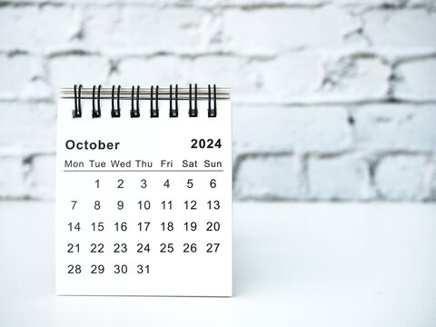 October 2024 white monthly desk calendar on a table