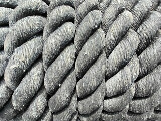 twisted rope, Thick weathered rope covered with dirt and rolled in coil in daytime in port, Braided hemp rope pattern for background, Old cotton big spiral cord in vertical position background.