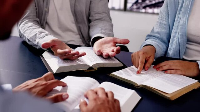 Young Latino man preaches from the Holy Bible, leading a circle of friends