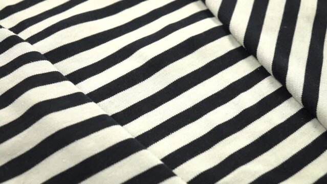 Black and white randomly folded striped fabric, background, slow motion