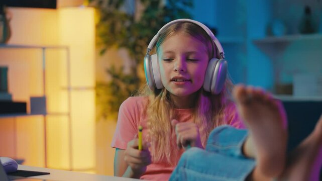 Happy girl wearing headset sings a song instead of doing homework, leisure