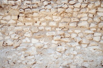 Ancient stone wall with irregularly shaped rocks and a rough texture.