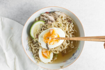 Overhead view of soft boiled eggs in chopsticks, top view of boiled eggs