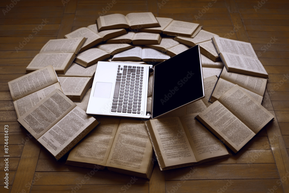 Wall mural an open laptop on the table near round stack of books. side view. place for your text. e-book librar