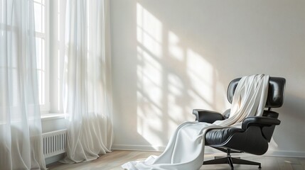 Minimalist bedroom with a single white silk scarf softly draped over a black leather chair