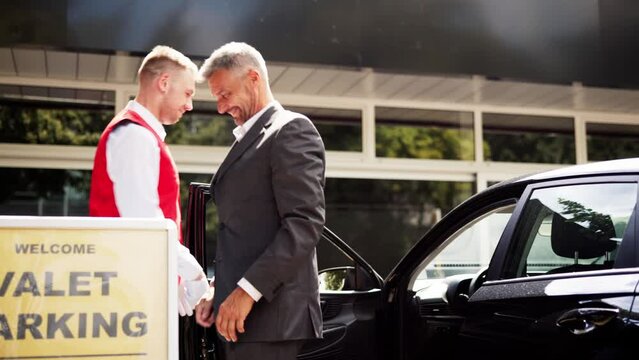 Luxury Valet Service: Giving Receipt to Young Businessman