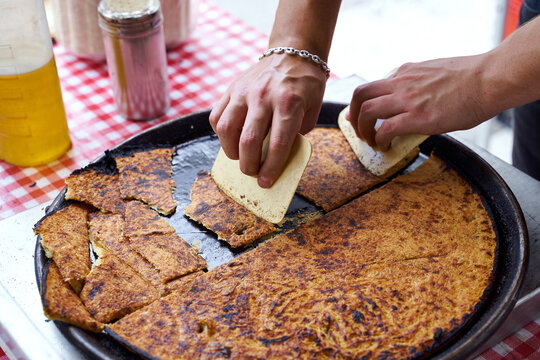 Socca, just coming out of the oven, in Nice, the French Riviera. a type of thin, Socca is a specialty of southeastern French cuisine. a pancake made from chickpea flour.