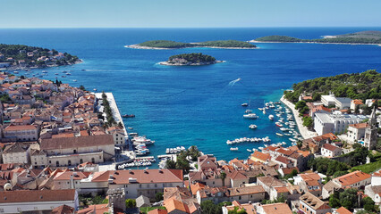 Picturesque view of Hvar town harbor with numerous sailboats and yachts anchored in turquoise waters of the adriatic sea