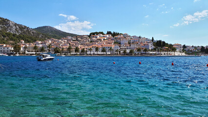 Small motorboat is anchoring in crystal clear turquoise waters near the picturesque town of Hvar on the croatian island hvar