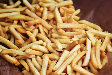 A Close-Up View of Golden French Fries on Brown Paper