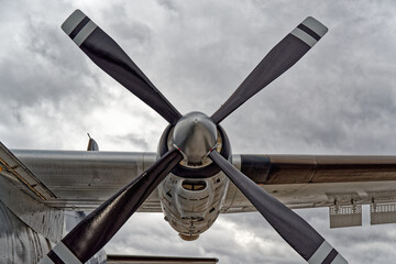 Conducting a detailed examination of the propeller blade with cloudy sky in the background....