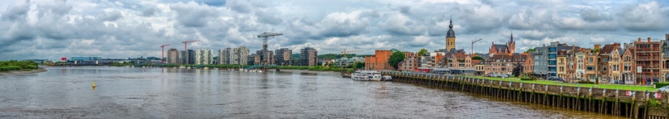 Obraz premium Temse Skyline - Cityscape With River and Cloudy Sky
