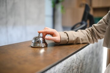 Hand of a woman using a hotel bell