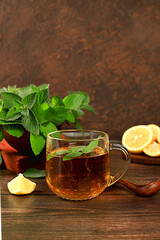 Medicinal herbal tea or infusion of peppermint with lemon with flowers, concept of alternative...