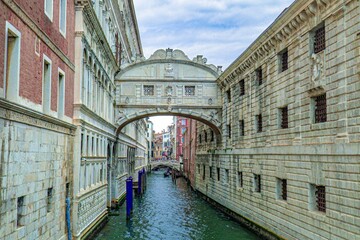 Obraz premium View of the Bridge of Sighs over a canal in Venice, Italy with historic buildings on a cloudy day