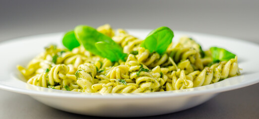 A plate of pasta with spinach on top