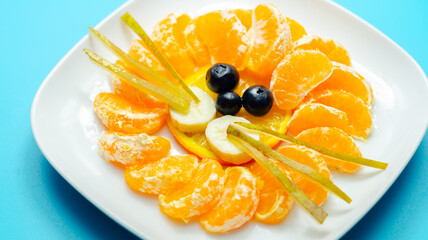 A plate of fruit with a face lion drawn on it