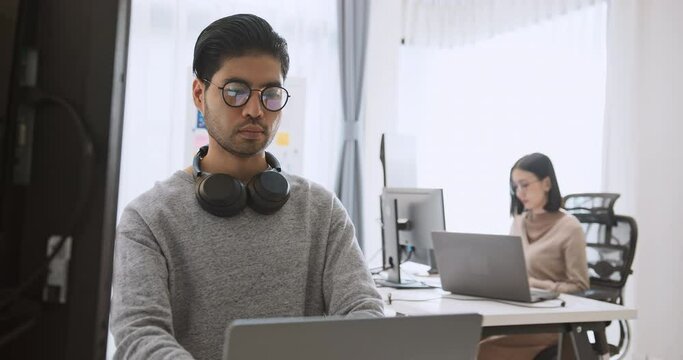 Young adult Asian male, female software developer coding program on desktop computer. Man, woman work from home, remote working, freelance programmer job, smart digital nomad lifestyle concept