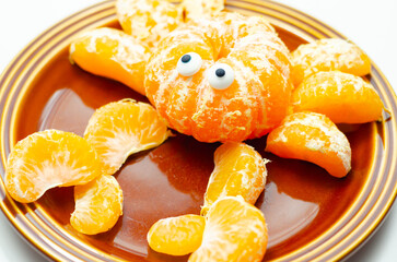 A plate of orange slices with a crab design made out of the slices