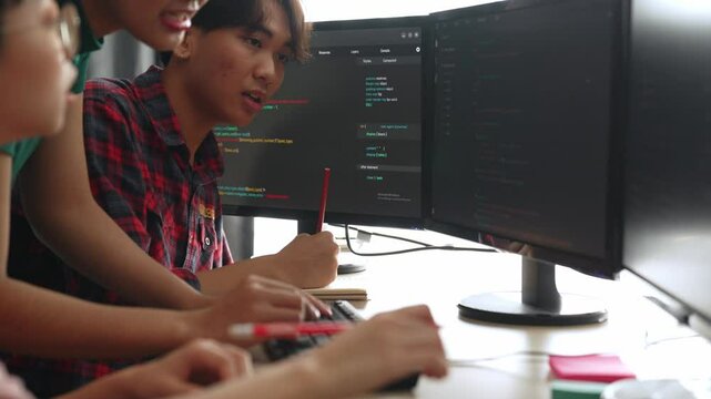 Slow motion back end software developer engineer for computer programming working together on debugging writing computing code, solving complex algorithms display on monitor in office. Burgeoning
