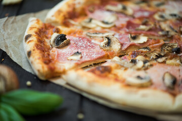Delicious pizza with cheese, ham and mushrooms. Pizza with a thick side, Italian style.