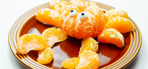 A plate of orange slices with a crab design made out of the slices