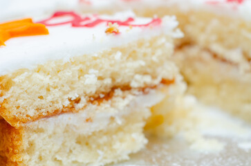 A slice of white cake with color frosting on top