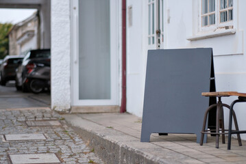 Minimalist Street Scene with Blank Chalkboard Sign Mock-Up and Stool Outside Shop