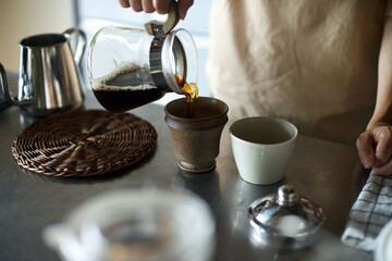 ドリップし終えたコーヒーをカップに注ぐところ
