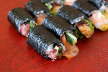 漆塗りの板にのせた様々な種類の巻きずし