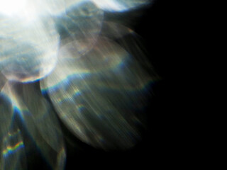 A blurry image of a light flare with a dark background. The image has a moody and mysterious feel to it. Background for design and special effects