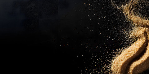 Obraz premium Splash of sand on a black background. explosion of sand with empty space. dry sand