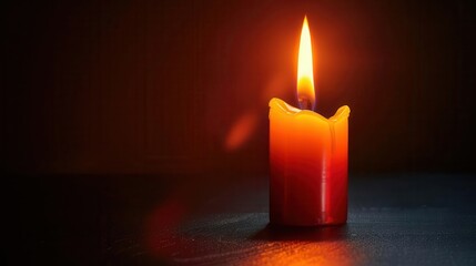 lit candle sitting on a table in the dark