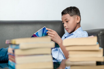 An Indonesian boy is reading a book