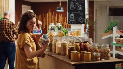 Customers shopping in eco friendly zero waste supermarket run by zealous storekeeper. Clients purchasing freshly harvested food from environmentally friendly local neighborhood store