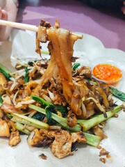 a portion of Fried Egg Kwetiau at a Chinese restaurant, served separately with chili sauce