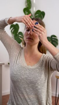 beautiful caucasian woman massaging her temples and face with manual quartz massager, facial yoga and anti aging