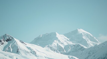 Obraz premium A snowy mountain range against a blue sky.
