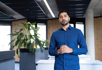 Business professional in modern office standing and speaking confidently to camera