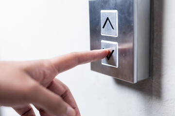 Pressing elevator button, person selecting floor in modern office building