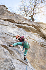 Young man climbing a challenging route on a cliff. Extreme sport.