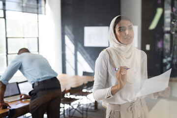 Presenting business strategy, woman holding paper and marker in modern office